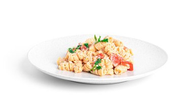 Beyaz arka planda bulunan peynirli makarna, domates ve otlar. Feta makarna.