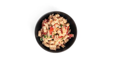 Beyaz arka planda bulunan peynirli makarna, domates ve otlar. Feta makarna.