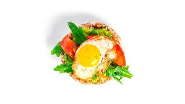 Crispbread sandwich with guacamole, arugula, tomatoes and quail egg isolated on a white background. Bruschetta with avocado. Healthy breakfast.