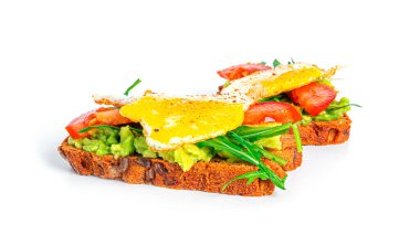 Rye bread sandwich with guacamole, arugula, tomatoes and quail egg isolated on a white background. Bruschetta with avocado. Healthy breakfast.
