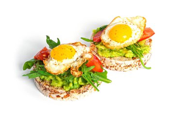 Crispbread sandwich with guacamole, arugula, tomatoes and quail egg isolated on a white background. Bruschetta with avocado. Healthy breakfast.