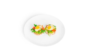 Crispbread sandwich with guacamole, arugula, tomatoes and quail egg isolated on a white background. Bruschetta with avocado. Healthy breakfast.