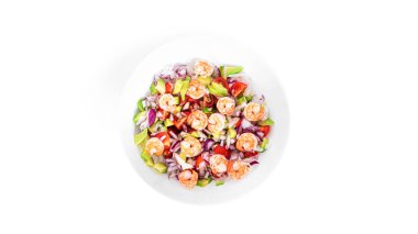 Beyaz arka planda karidesli salata, dilimlenmiş domates, soğan ve avokado..