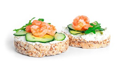 Krem peynir, salatalık ve roka yapraklı, beyaz bir zemin. Kadeh kaldırma. Sandviç izole edilmiş. Karides, somon ve peynirli sandviç..