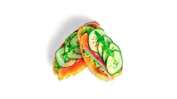 Knäckebrot-Sandwich mit Guacamole, Lachs, Rucola, Gurke isoliert auf weißem Hintergrund. Bruschetta mit Avocado. Gesundes Frühstück. — Stockfoto