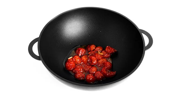 Párolt cseresznye paradicsom fokhagymával egy wok serpenyőben elszigetelt fehér alapon. A bucatini tészta elkészítése. — Stock Fotó