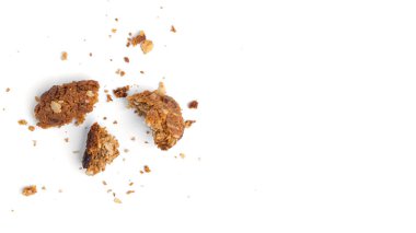 Beyaz arka planda üzümlü ve hindistan cevizli yulaflı kurabiyeler. Kırıntılar. Yukarıdan görüntüle.