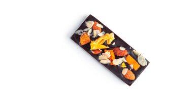 Beyaz arka planda kurutulmuş meyve ve fındıklı çiğ çikolata..