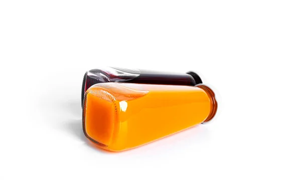 Orangen- und Kirschsaft in der Flasche isoliert auf weißem Hintergrund. — Stockfoto