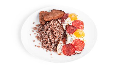 Beyaz arka planda kızarmış yumurta ve pastırmalı karabuğday lapası..