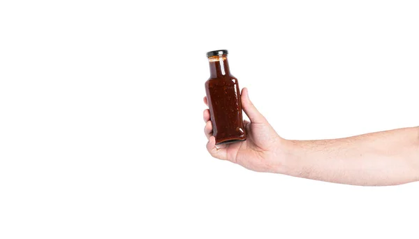 Molho em uma garrafa isolada em um fundo branco. Garrafa na mão. — Fotografia de Stock