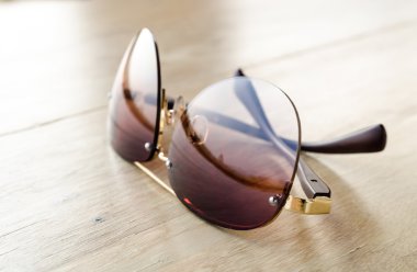 Ahşap masada moda güneş gözlükleri.