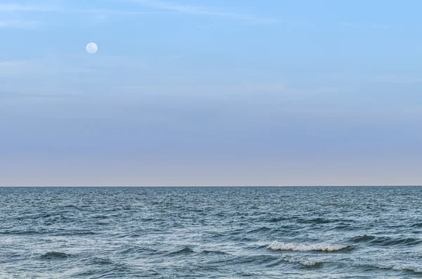 Full moon rising over empty ocean at night with copy space, Lighting Moon on sea - empty composition
