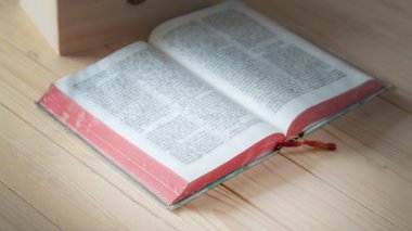 Tahta bir masanın üzerinde açık bir kitap.