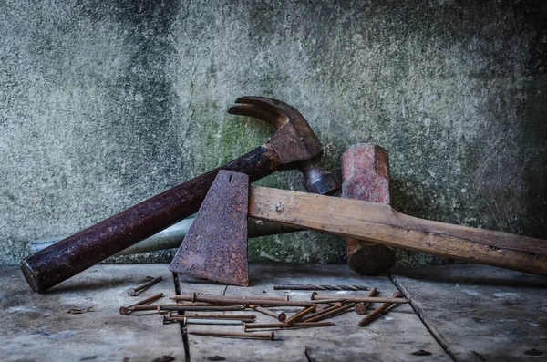 Velho machado enferrujado e martelo com unhas velhas — Fotografia de Stock