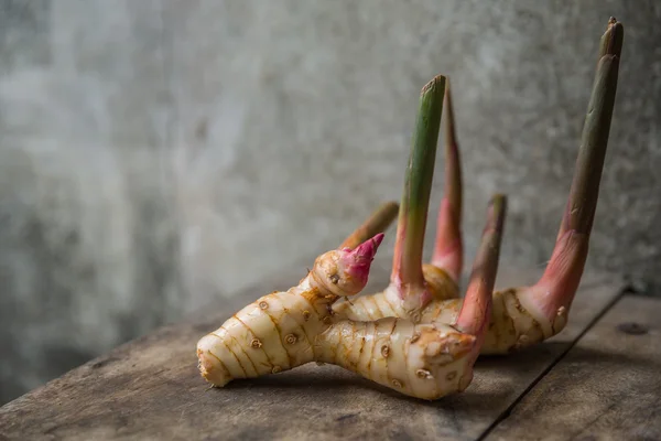 Galangal na drewnianym stole — Zdjęcie stockowe