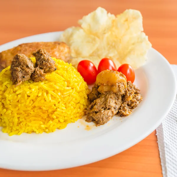 Kurkuma-Reis mit vegetarischem Rendang und Krupuk — Stockfoto