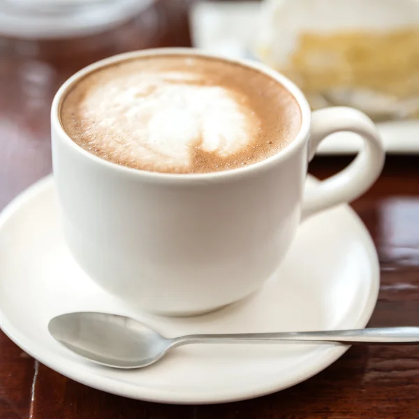 Чашка кофе на коричневом деревянном столе — стоковое фото