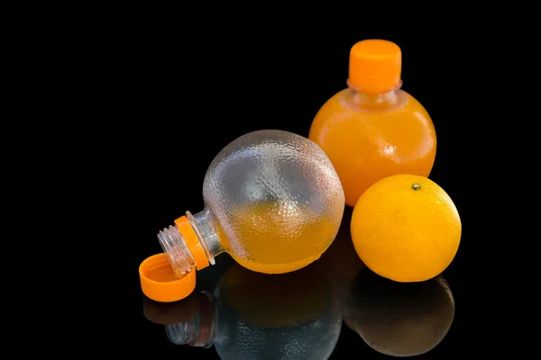 El jugo de naranja en las botellas con la fruta de naranja —  Fotos de Stock