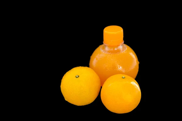 Sumo de laranja numa garrafa com laranjas maduras — Fotografia de Stock