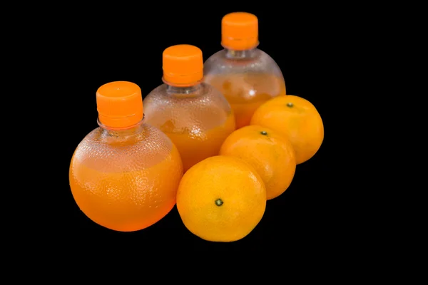 Jugo de naranja en botellas y frutas de naranja —  Fotos de Stock