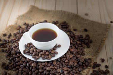 Kahve fincanı ve çay tabağı ahşap bir masada.