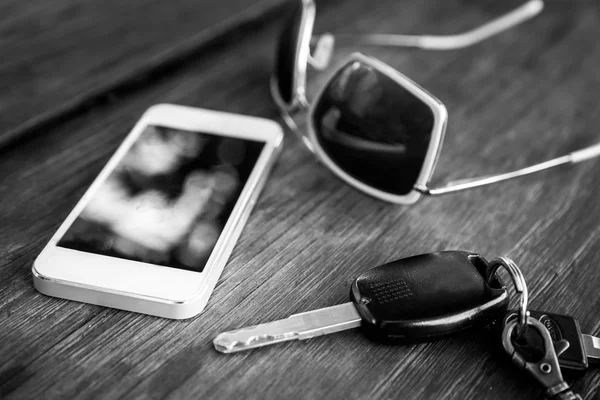Ключ от машины со смартфоном и солнечными очками — стоковое фото