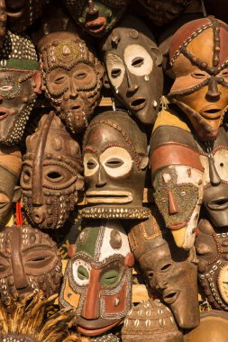Geleneksel Afrikalı maskeleri bir market tezgahında asılı duruyor..