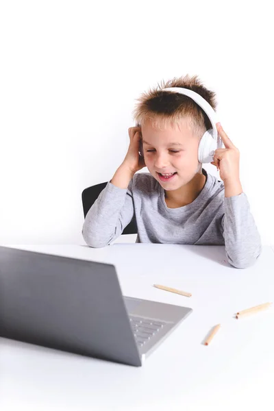 Pionowy Portret Blond Kaukaskiego Dzieciaka Słuchawkami Patrzącego Ekran Laptopa Białym — Zdjęcie stockowe