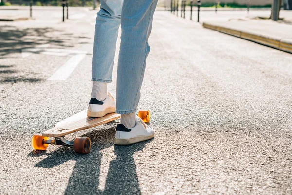 legs and feet of a man on a skateboard in the street