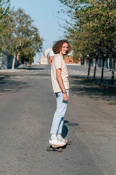 Homem ruivo caucasiano patinando na estrada de uma cidade — Fotografia de Stock