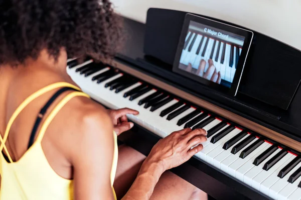 Piano online learning of an african young woman — Stock Photo, Image