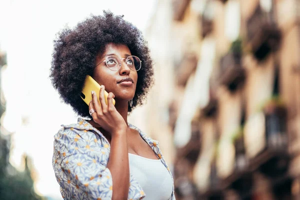 Sokakta telefonla konuşan Afrikalı bir kadının yatay portresi
