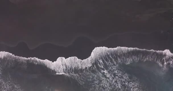 Vista aérea. Imagens aéreas impressionantes de ondas quebrando contra a bela praia de areia preta islandesa. — Vídeo de Stock