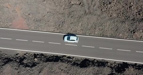 Vista aérea. Conducir por carretera en el paisaje rocoso volcánico del desierto. — Vídeo de stock