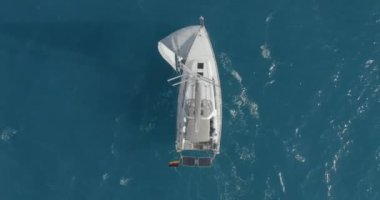 Açık deniz anteninde yüzen yansımalı bir yat. Okyanus körfezinde yüzen yelkenli tekneyle kimse deniz manzarası yapamaz. İskoçya, Arran Adası 'nın dağ manzarası. Sinematik yaz tatili manzarası.