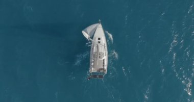 Açık deniz anteninde yüzen yansımalı bir yat. Okyanus körfezinde yüzen yelkenli tekneyle kimse deniz manzarası yapamaz. İskoçya, Arran Adası 'nın dağ manzarası. Sinematik yaz tatili manzarası.