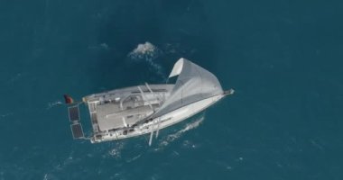 Açık deniz anteninde yüzen yansımalı bir yat. Okyanus körfezinde yüzen yelkenli tekneyle kimse deniz manzarası yapamaz. İskoçya, Arran Adası 'nın dağ manzarası. Sinematik yaz tatili manzarası.
