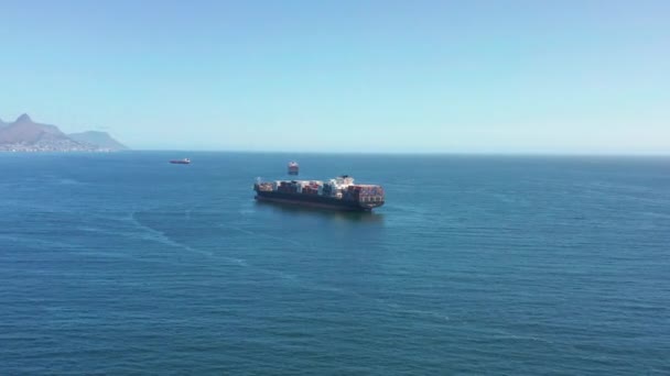 Bovenaanzicht vanuit de lucht van een vrachtschip dat containers vervoert en met sleepboot goederen uitvoert van een vrachthaven naar een aangepaste oceaan. concept vrachtvervoer per schip. — Stockvideo