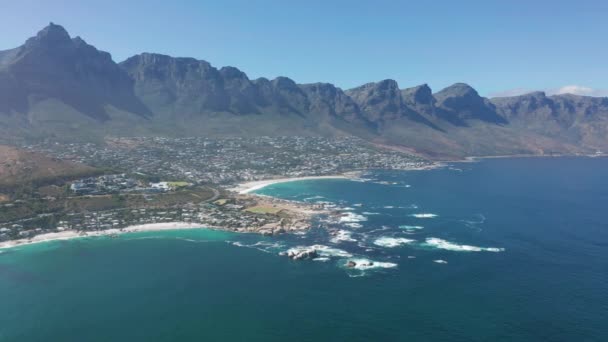 Vista aérea. Litoral de Camps Bay, Cidade do Cabo, África do Sul, com doze montanhas Apóstolos. CAPE TOWN, ÁFRICA DO SUL. — Vídeo de Stock