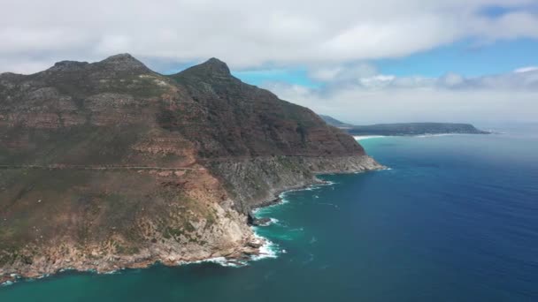 Flygfoto. Chapmans Peak Drive nära Kapstaden, Sydafrika. Ovanifrån av vägen går genom vackert landskap. Väg böja längs havet. — Stockvideo