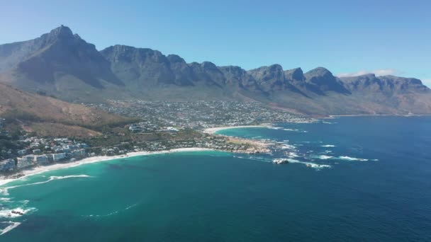 Luftbewegung entlang der Küste von Camps Bay, Kapstadt, Südafrika, mit den Zwölf Aposteln Bergen. KAPSTADT, SÜDAFRIKA. — Stockvideo
