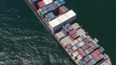 Kargo gemisinin kargo konteynırını taşıdığı ve kargo limanından özel okyanusa mal ihraç etmek için römorkör ile koştuğu hava görüntüsü. konsept nakliyat gemiyle.