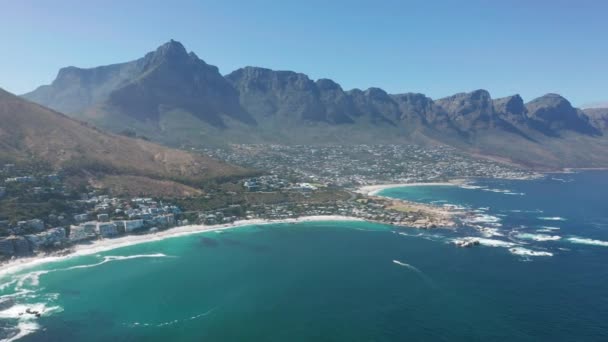 Flyg rör sig längs kusten av Camps Bay, Kapstaden, Sydafrika, med tolv apostlar berg. CCAPE TOWN, SOUTH AFRICA. — Stockvideo