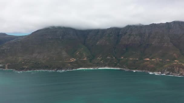 Vista aérea. Chapmans Peak Drive cerca de Ciudad del Cabo, Sudáfrica. Vista superior de la carretera pasando por un hermoso paisaje. Camino de flexión a lo largo del océano. — Vídeos de Stock