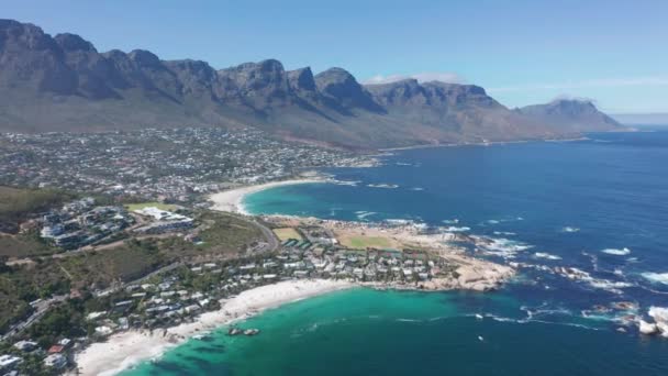 Aerial moving along the shoreline of Camps Bay, Cape Town, South Africa, with Twelve Apostles mountains. CAPE TOWN, SOUTH AFRICA. — Stock Video