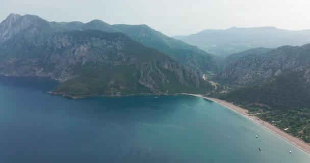 아름다운 날 이 밝게 비치는 시 랄리 해변의 공중 드론 과 올름푸스 오림 포스 산. Kemer, Antalya, Mediterranean region, Turkey, Lycia. 완벽 한 바다 경치, 여행자의 눈에 좋은 곳. — 비디오