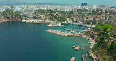 Hava görüntüsü. Antalya 'nın Antalya Körfezi' nde güneşli bir günde İHA 'nın en yüksek noktasından uçuyor. Kuşlardan inanılmaz bir şehir manzarası. Güzel şehir ve deniz yatlarla dolu..