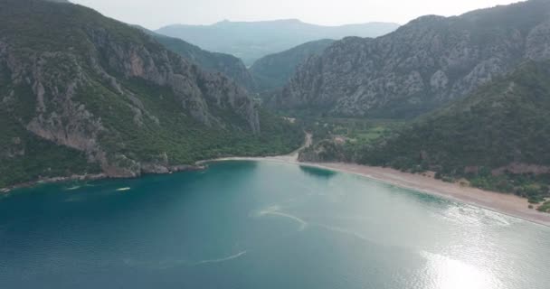 아름다운 날 이 밝게 비치는 시 랄리 해변의 공중 드론 과 올름푸스 오림 포스 산. Kemer, Antalya, Mediterranean region, Turkey, Lycia. 완벽 한 바다 경치, 여행자의 눈에 좋은 곳. — 비디오