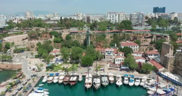 Flygfoto. Antalya Bay i Antalya stad från hög punkt drönare flyga på solig dag i Turkiet. Fantastisk antenn stadsbild utsikt från fåglar flyga höjd på vacker stad och hav full av båtar. — Stockvideo